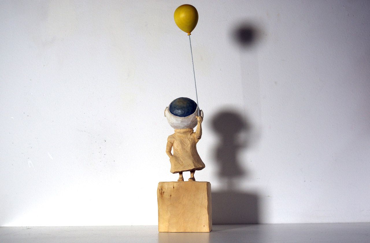 Holzskulptur aus der Reihe Terranauten (Kind mit Luftballon) von Nadine Elda Rosani
