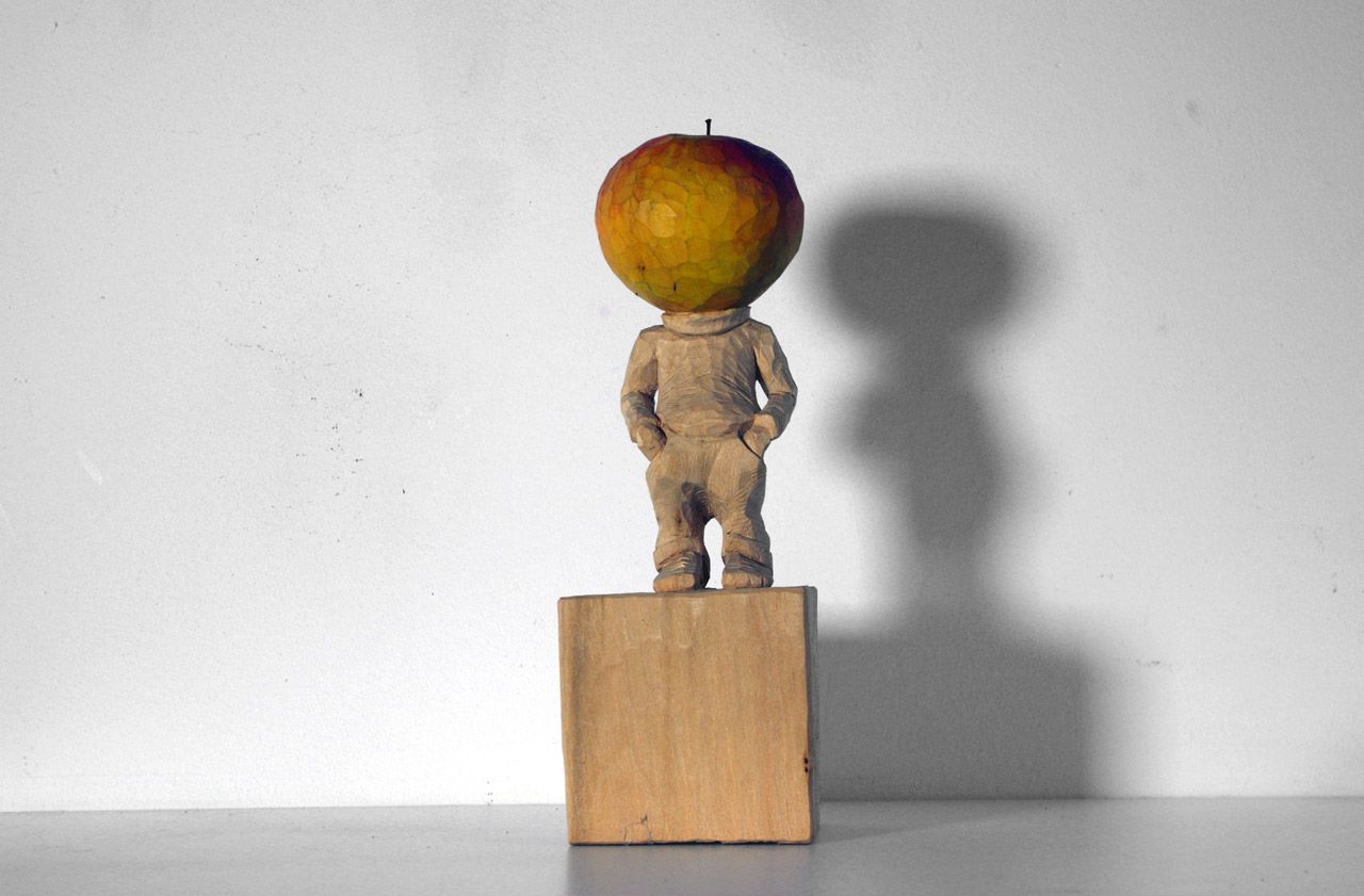 Holzskulptur aus der Reihe Neard Heads (mit Apfelkopf) von Nadine Elda Rosani